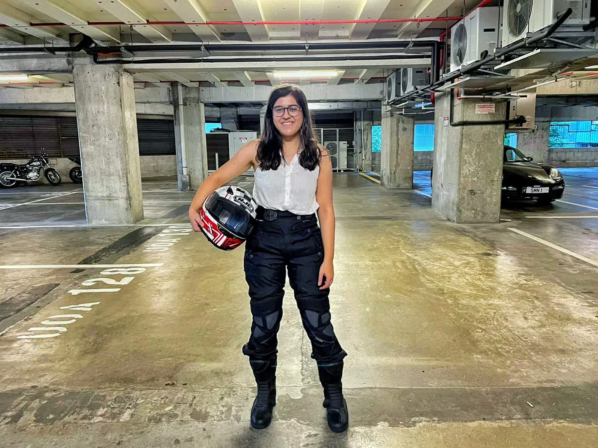 Standing with motorcycle helmet after earning a motorcycle licence in New Zealand
